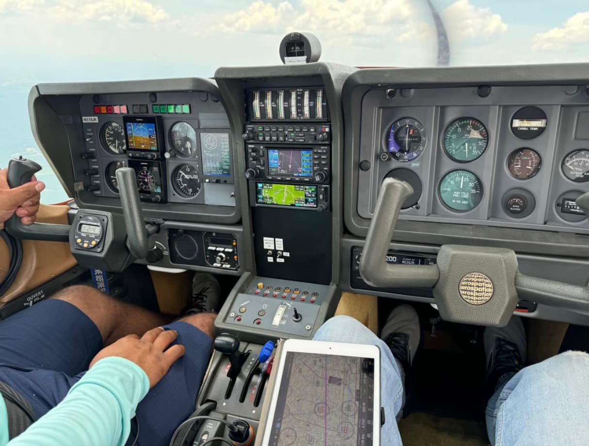 TB10 cockpit with upgraded Garmin avionics — instructor and student in flight