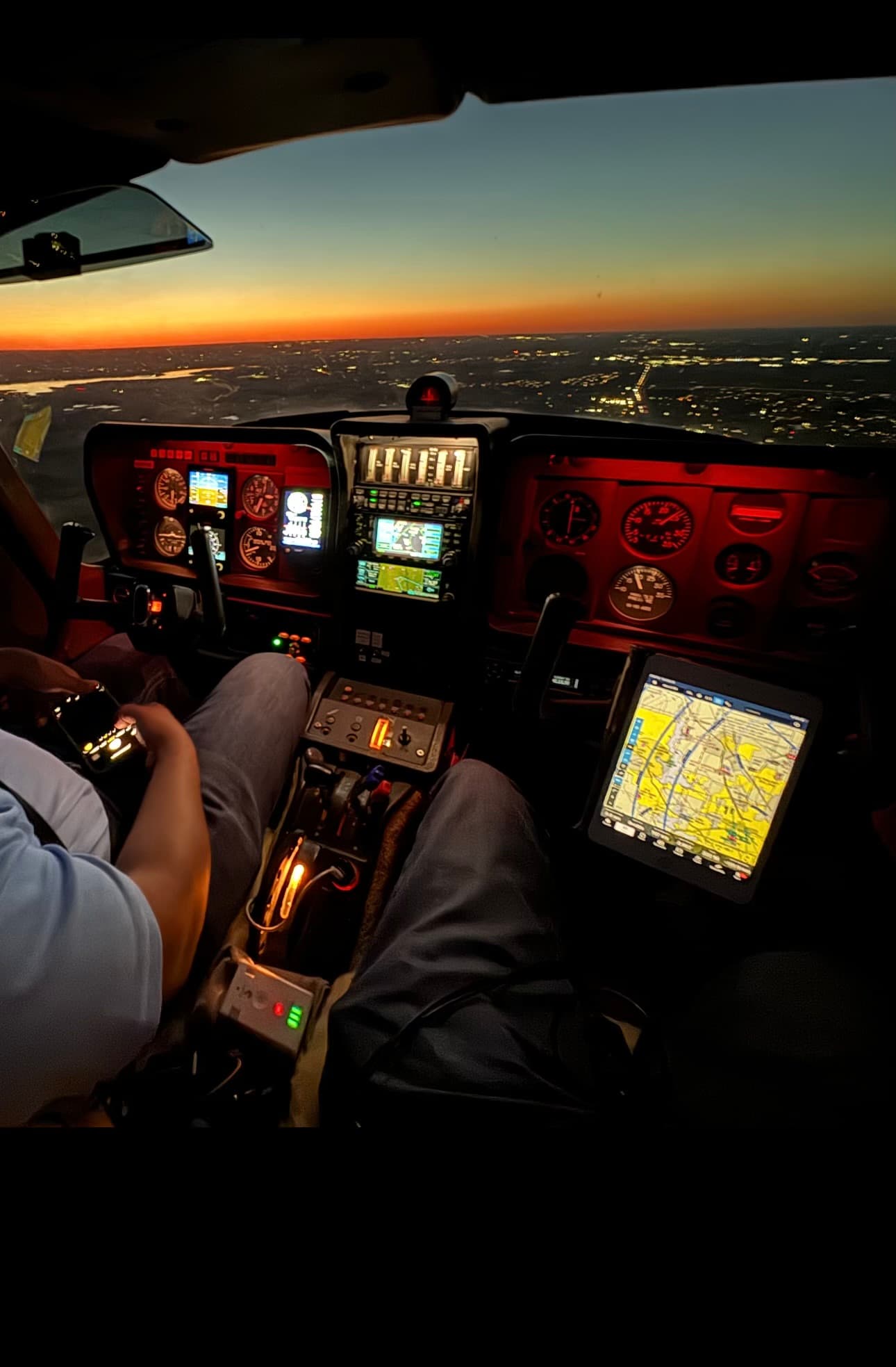 TB10 cockpit instrument panel during a night flight over city lights