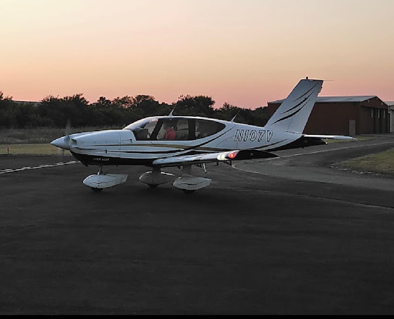 TB10 aircraft parked outside the hangar at dusk