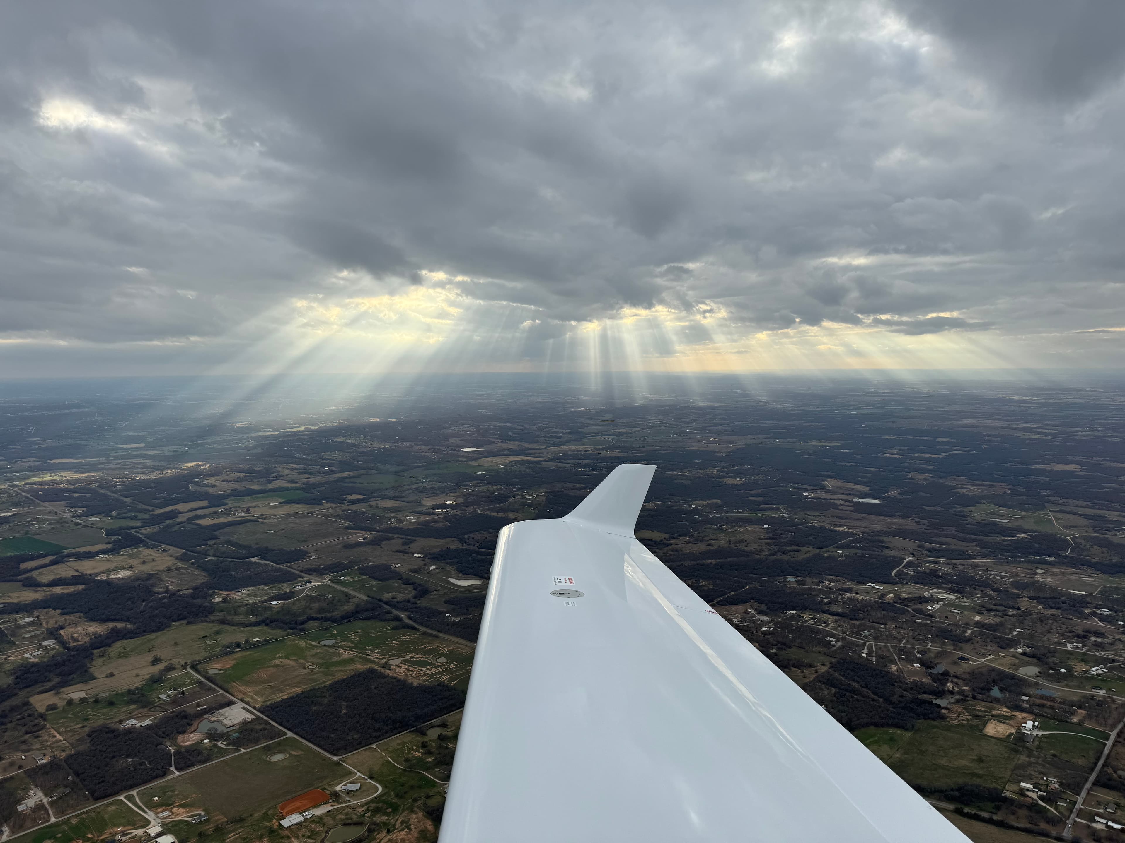 Above the clouds with golden sun rays streaming through the windshield